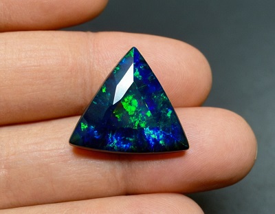 Opale noire en triangle, chatoyante, dégradée du vert éclatant au bleu profond, sa beauté est doublée à l'arrière, où une pointe noire accentue son éclat