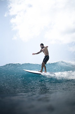 Comment faire du surf ? Le guide complet pour les débutants 2 surfeur débutant qui prend sa première vague
