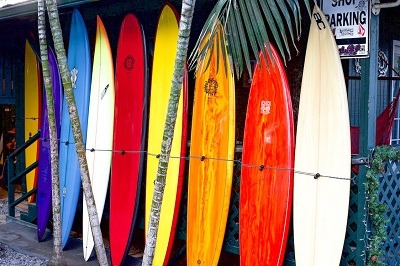 plusieurs planches de surfs posé contre une baraque en bois