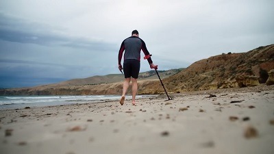 prospecteur qui détecte avec un détecteur vanquish sur une plage