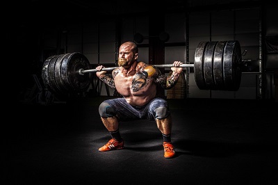 Homme soulevant une barre de poids de musculation