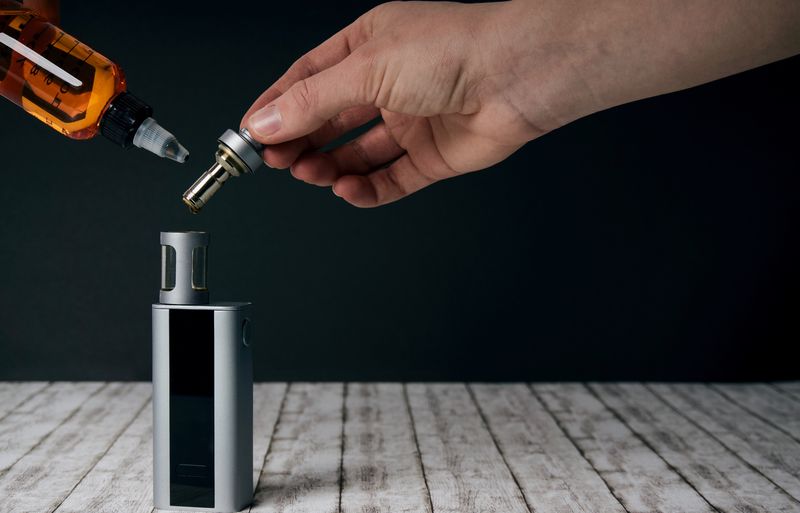 Une main en train de doser de l'e-liquide